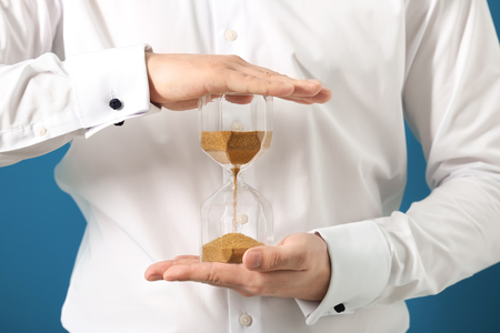 Man holding hourglass, closeup. Time management concept
