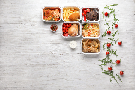 Containers with delicious food on wooden table. Delivery serviceの写真素材