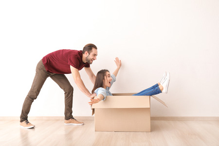 Young couple playing with box indoors. Moving into new houseの写真素材
