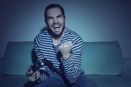 Young man playing video games at home