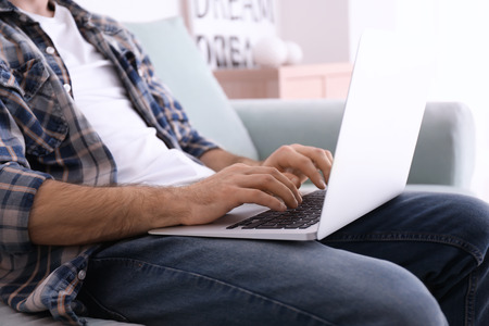 Male freelancer working with laptop in home officeの写真素材