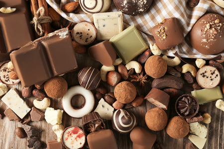 Yummy chocolate candies with nuts on wooden tableの写真素材