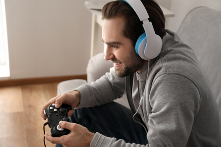 Young man playing video games at homeの写真素材