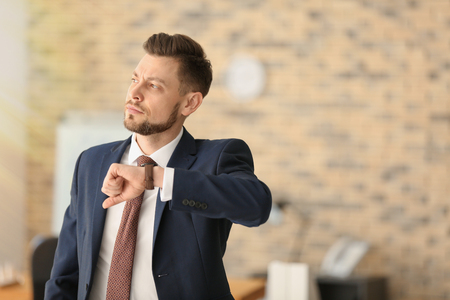 Businessman with wristwatch in office. Time management conceptの写真素材