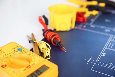 Electrician's supplies with electrical scheme on white background