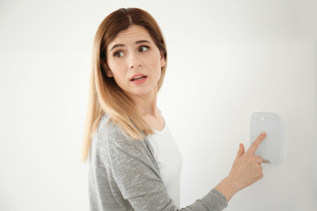 Frightened woman using security system indoorsの写真素材