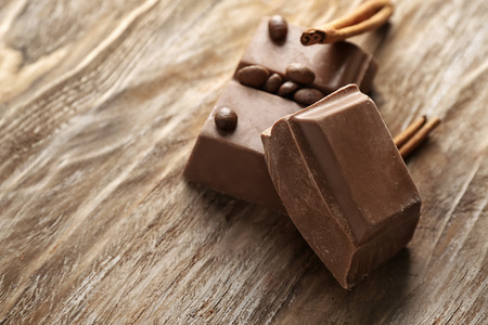 Milk chocolate with cinnamon on wooden background