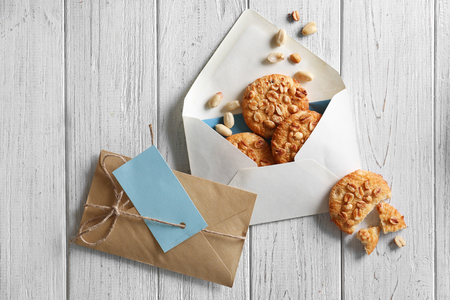 Flat lay composition with envelopes and cookies on wooden background. Mail serviceの写真素材