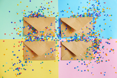 Mail envelopes with confetti on color background