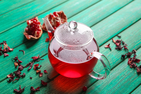 Glass teapot of hot aromatic tea on wooden tableの写真素材