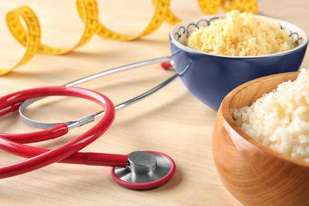 Bowls with porridge and stethoscope on table. Healthy food conceptの写真素材