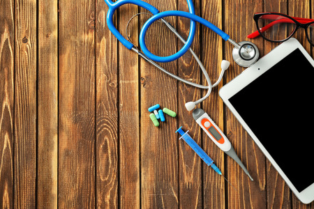 Composition with stethoscope and tablet PC on wooden background. Health care conceptの写真素材