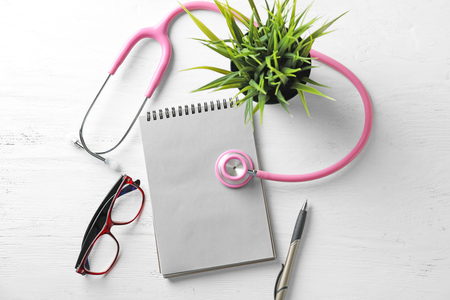 Stethoscope with notebook on wooden background. Health care conceptの写真素材
