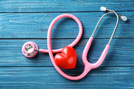 Stethoscope with red heart on wooden background. Health care conceptの写真素材
