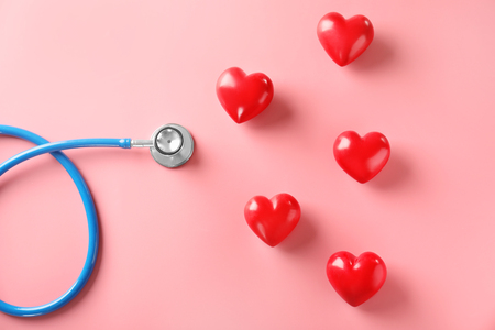Stethoscope with red hearts on color background. Health care conceptの写真素材