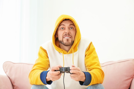 Emotional man playing video game at home