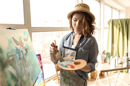 Female artist painting in workshopの写真素材