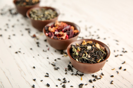 Variety of dry tea in bowls on tableの写真素材