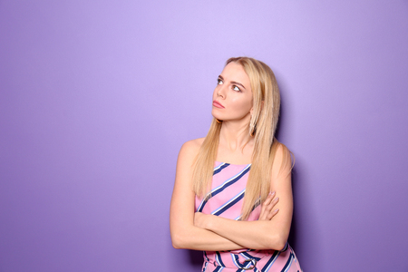 Portrait of displeased young woman on color backgroundの写真素材