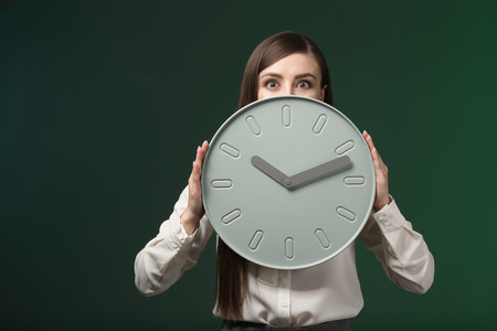 Woman with clock on color background. Time management conceptの写真素材