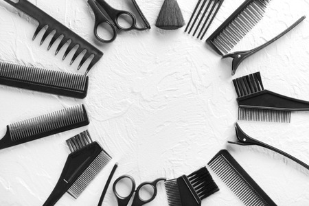 Frame made of professional hairdresser's tools on white textured background