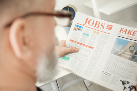 Senior man reading newspaper at home