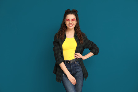 Stylish young woman on color background