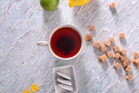 Cup of hot beverage and tea bags on tableの写真素材