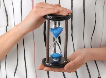 Woman holding hourglass, closeup. Time management conceptの写真素材