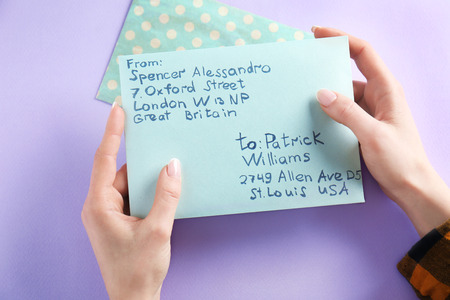 Woman holding envelope on color background