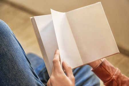 Man reading interesting book at home, closeup