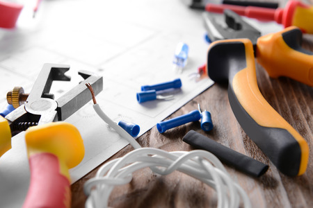 Electrician's supplies with house plan on table, closeup