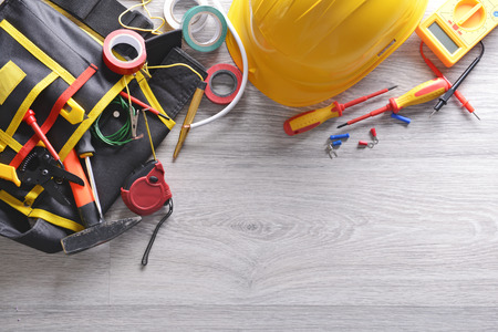 Electrician's supplies on wooden background