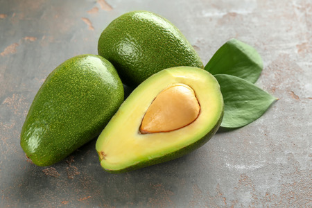Fresh avocados on grey table