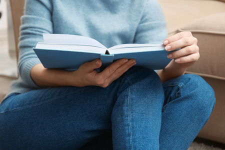 Young woman reading book at homeの写真素材