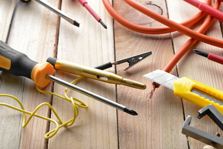 Electrician's supplies on wooden background