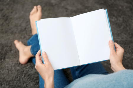 Young woman reading book at homeの写真素材