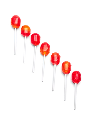 Tasty colorful lollipops on white background, flat lay