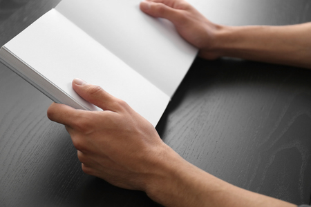 Man reading interesting book at home, closeupの写真素材