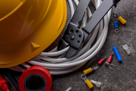 Electrician's supplies with hard hat on grey backgroundの写真素材