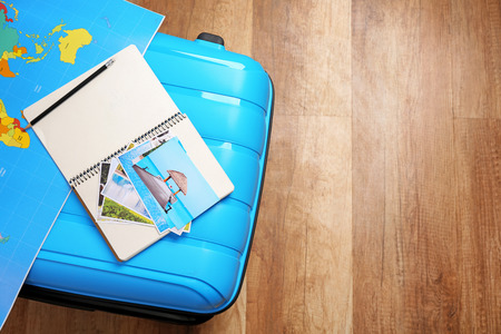 Packed suitcase, map and notebook on wooden floor. Travel conceptの写真素材