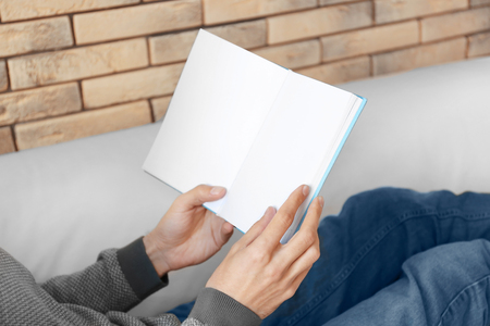 Man reading interesting book at homeの写真素材