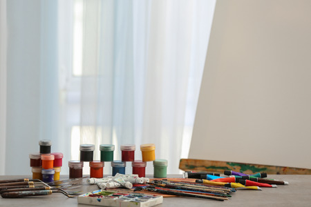 Set of tools and paints of professional artist on table in workshopの写真素材