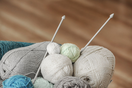 Knitting threads with needles on blurred background