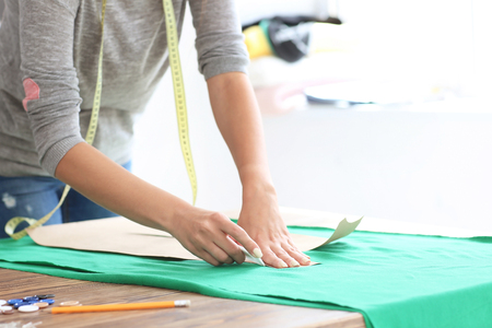 Young female tailor working with sewing pattern in atelierの写真素材
