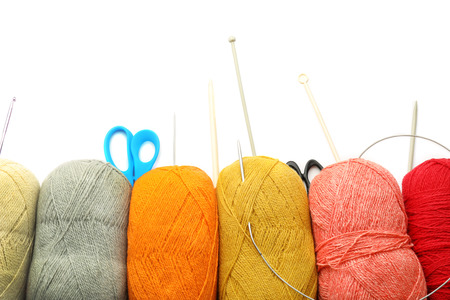 Threads, scissors and knitting needles on white background