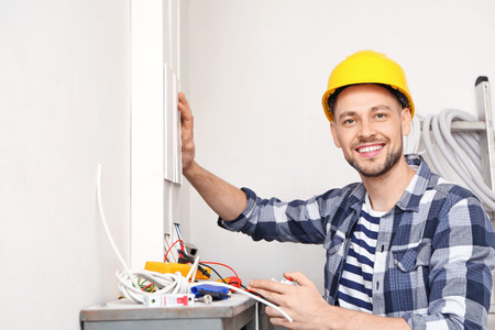 Electrician repairing distribution board indoorsの写真素材