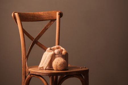 Box with knitting threads on chair against grey backgroundの写真素材
