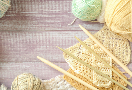 Unfinished knitting clothes with needles on wooden tableの写真素材