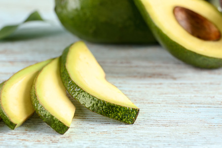 Fresh sliced avocado on wooden table